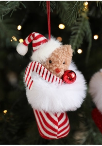 Detail of Christmas plush bear hanging ornament with candy cane in red and white boot