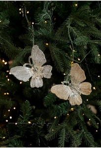 Close-up of gold and silver glitter butterfly ornaments hanging on a Christmas tree