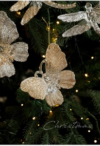 Detail of clear acrylic butterfly and dragonfly ornaments with gold glitter for Christmas trees