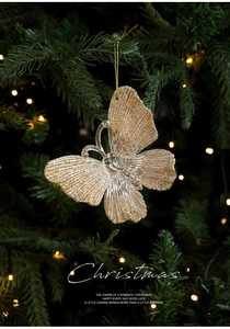 Close-up of butterfly Christmas tree ornament with gold glitter and crystal accent