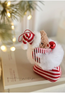Detailed view of a plush Christmas teddy bear in a red stocking with candy cane ornament