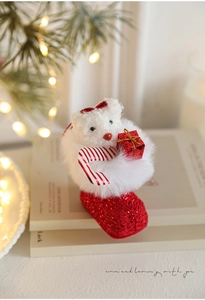 Detail of plush Christmas bear in sequined red boot with candy cane and gift box