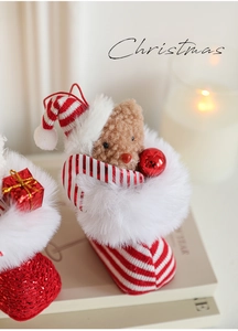 Close-up of plush teddy bear in red and white striped Christmas boot hanging ornament