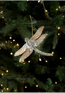 Detailed close-up of a sparkling gold glitter dragonfly ornament on a Christmas tree branch