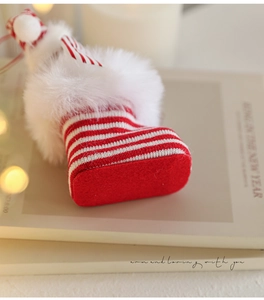 Detail of red and white striped knit Christmas boot ornament with soft faux fur trim