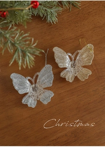 Detail of acrylic butterfly ornaments with glitter finish on rustic wooden surface