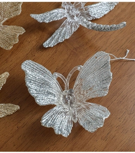 Close-up of glittery butterfly and dragonfly ornaments with detailed wings and hanging strings