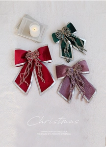 Detailed view of luxury velvet Christmas bows with silver edges and woven gold tassels