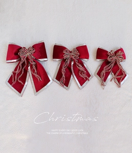Detail of three red velvet Christmas bows with sparkling silver glitter edges and knots