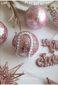 Détail de boules de Noël roses avec étoiles pailletées, perles et signe Merry Christmas