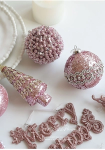 Détails de décorations de Noël roses avec boules pailletées et plaque Joyeux Noël