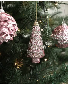 Détail de décorations de Noël à paillettes roses avec filigrane argenté sur sapin