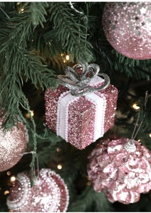 Décoration de Noël en boîte cadeau rose pailletée avec perles sur un sapin