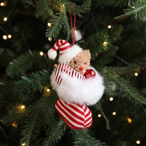 Christmas plush bear ornament wearing red white striped stocking and hat on Xmas tree
