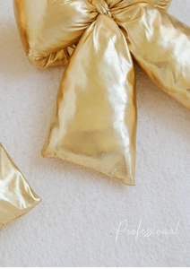 Detailed macro view of large shiny golden Christmas bow decoration with metallic finish