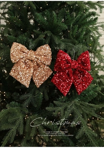 Detail von glitzernden roten und champagnerfarbenen Pailletten Weihnachtsbaum Schleifen