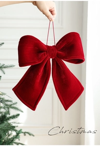 Detail of large red velvet Christmas bow featuring plush filling and elegant hanging loop