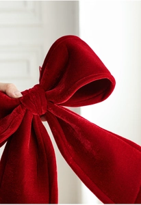 Detailed close-up of red velvet Christmas bow showing rich texture and premium fabric