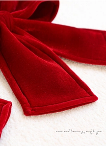 Macro view of red velvet Christmas bow with fine stitching and soft texture