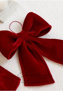 Macro detail of red velvet Christmas bow showing soft plush texture and golden velvet sheen
