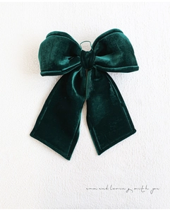 Close-up of deep green velvet Christmas bow ornament with high-density fabric texture