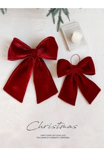Macro view of plush deep red velvet Christmas bows set on soft faux fur surface