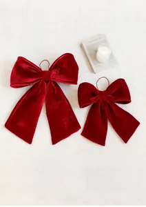 Close-up of velvet Christmas bow ornaments with fine texture on a cozy white plush surface