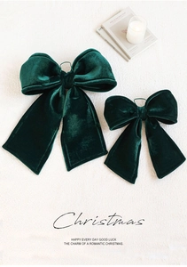 Detail of two dark green velvet Christmas bows showing soft texture and premium festive finish