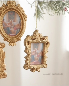 Detail view of vintage gold baroque mini photo frames hanging on a Christmas tree