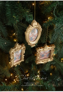Close-up of three vintage gold mini photo frames hanging as Christmas tree decorations