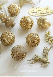 Detailed collection of champagne gold Christmas ornaments including reindeer and glitter balls