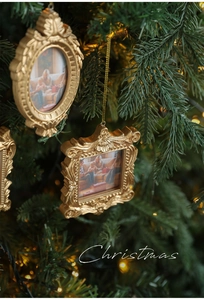 Detail of vintage gold Christmas tree photo frame charms with embossed patterns