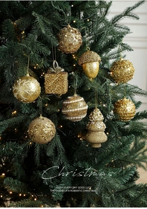 Detailed close-up of luxury gold Christmas ornaments with sequins on tree branches