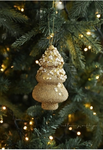 Close-up of golden Christmas tree ornament with glitter sequins and white pearls