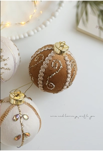 Macro shot of 8cm Christmas ball with brown fabric and gold glitter spiral patterns