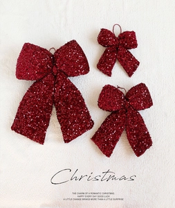 Three-piece set of burgundy sequined Christmas bow ornaments on a soft velvet background