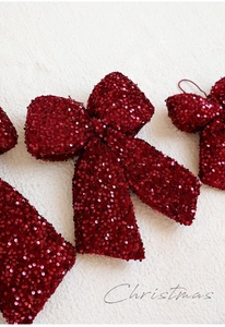 Close-up of deep red sequins on decorative Christmas bows for holiday tree ornaments