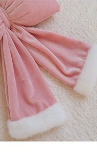 Détail d'un nœud de Noël en velours rose avec bordure en peluche blanche douce