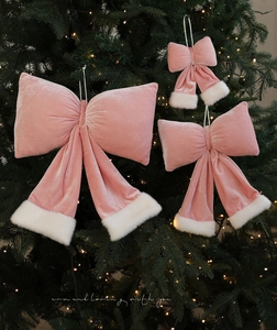 Trois nœuds de Noël en velours rose avec bordure en fourrure sur un sapin