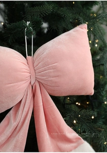 Gros plan d'un nœud de Noël en velours rose avec bordure en fausse fourrure blanche
