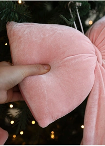 Gros plan d'un nœud de Noël en velours rose montrant la texture douce et la qualité