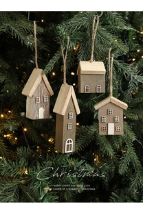 Close-up of wooden house ornaments with warm lights on a festive Christmas tree