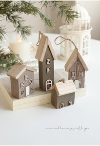 Detail of four miniature wooden Christmas houses with natural grain and white window prints