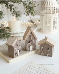 Detailed view of three handcrafted wooden Christmas house ornaments with rustic hanging ropes