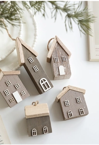 Detail showing five mini wooden Christmas house ornaments with rustic textures and hemp ropes