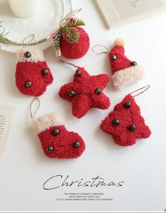 Close-up of plush red and beige Christmas ornaments with bells and festive ribbons
