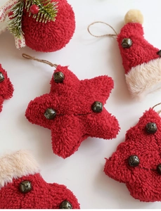 Detail of red plush Christmas ornaments with beige faux fur trim and bronze metal bells