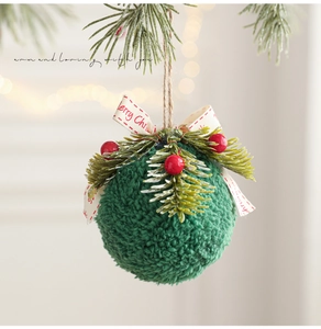 Detailed close-up of green plush Christmas ornament with red berries and pine needle accents