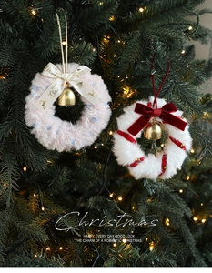 Detail of plush Christmas wreath ornaments with ribbons, golden bells and Merry Christmas text