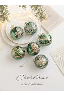 Close-up of green shiny Christmas balls with golden glitter patterns on a white tray